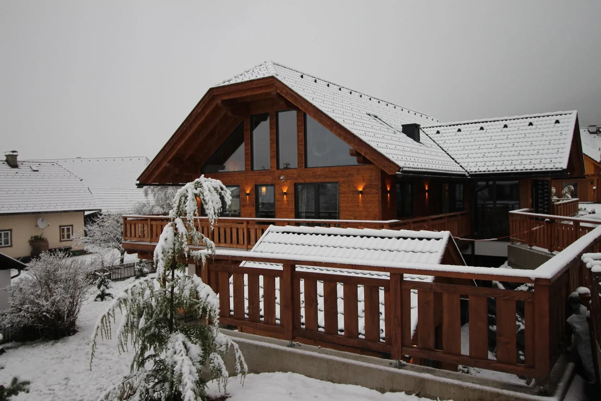 Balkon mit verschneiten Tannen vor dem Chalet
