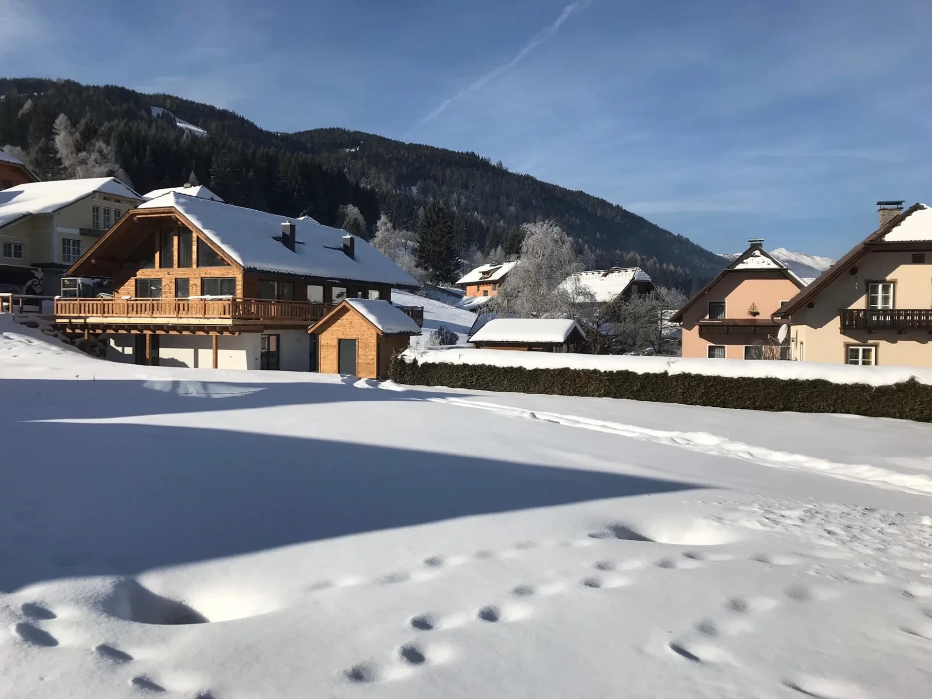 Die Chalets in einer verschneiten Landschaft unter strahlend blauem Himmel