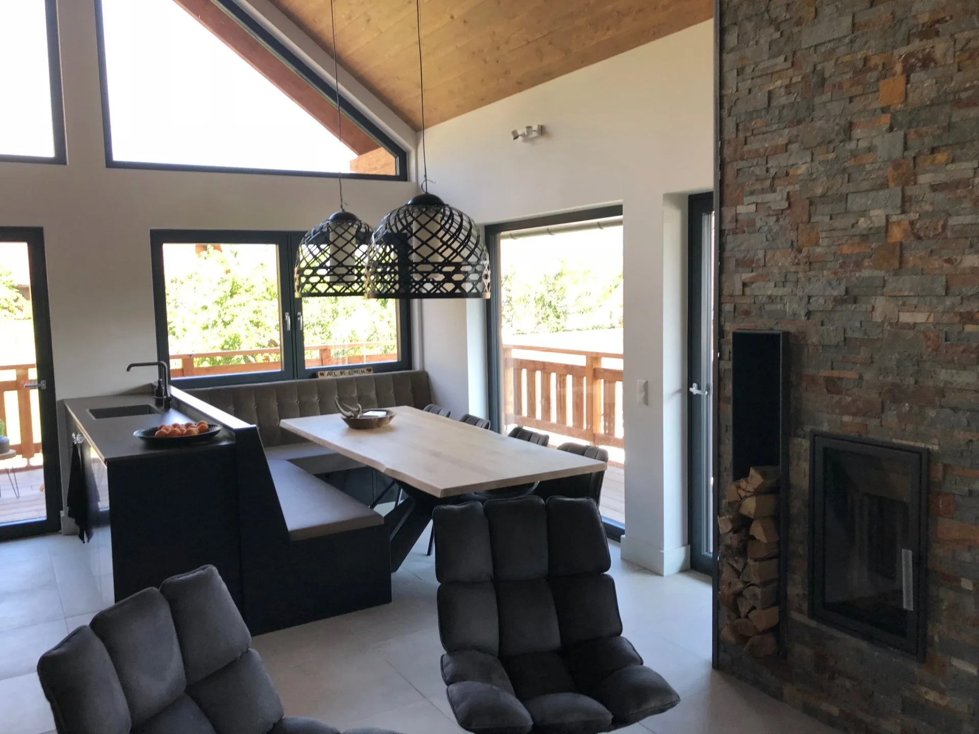 Open-plan kitchen with dining table and wood stove