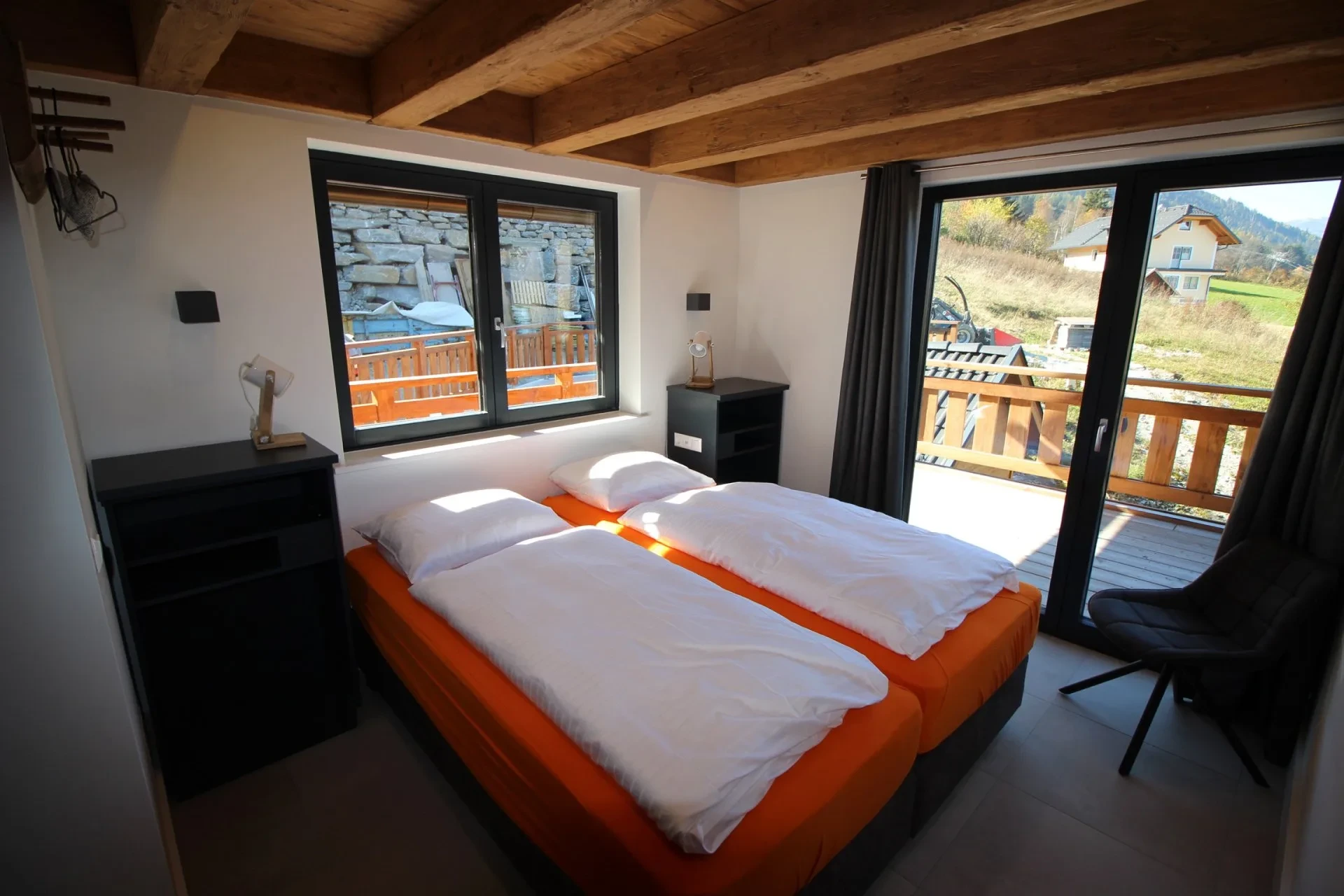Bedroom with wooden beamed ceiling and balcony