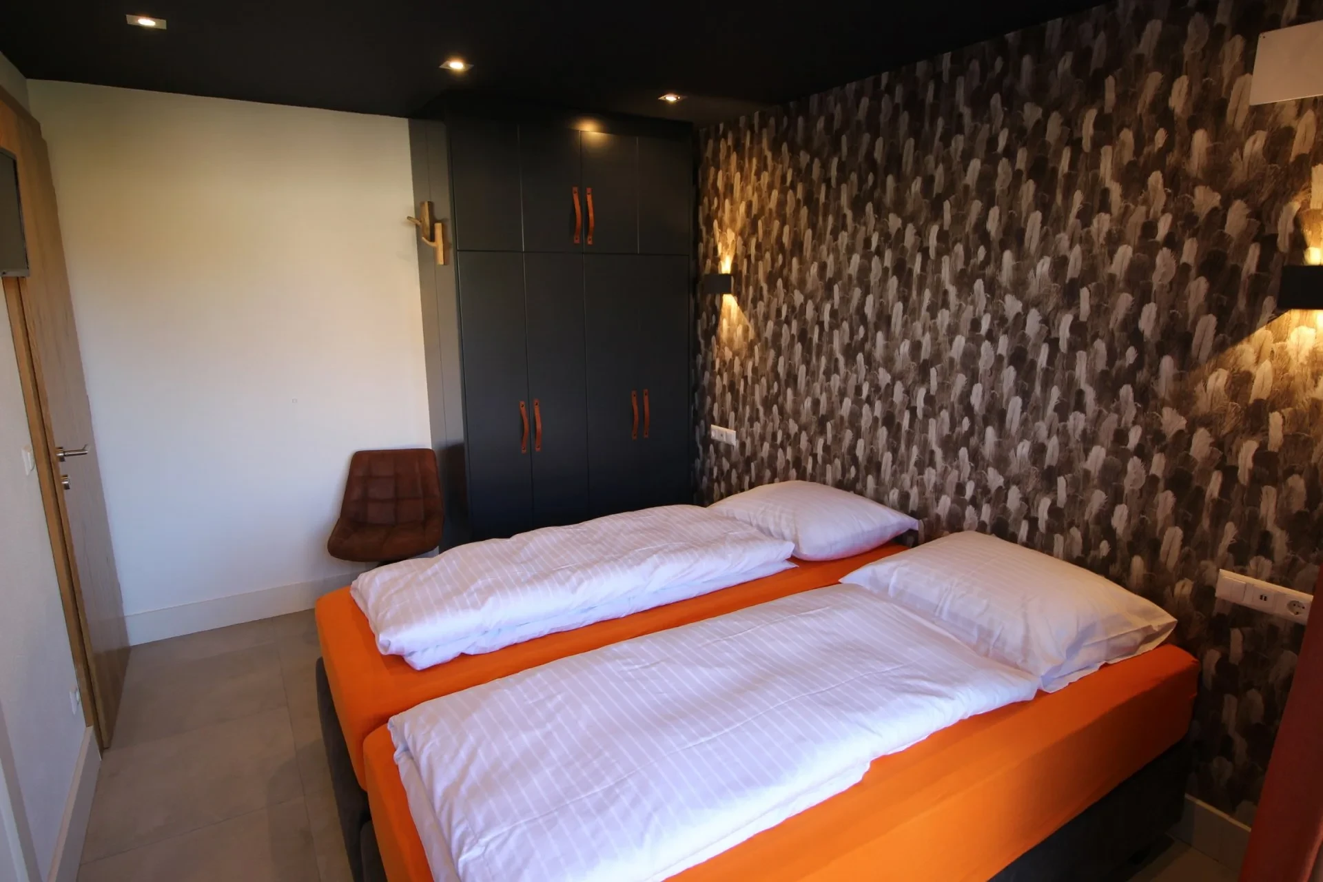 Bedroom with wood-pattern wallpaper and extra-long beds