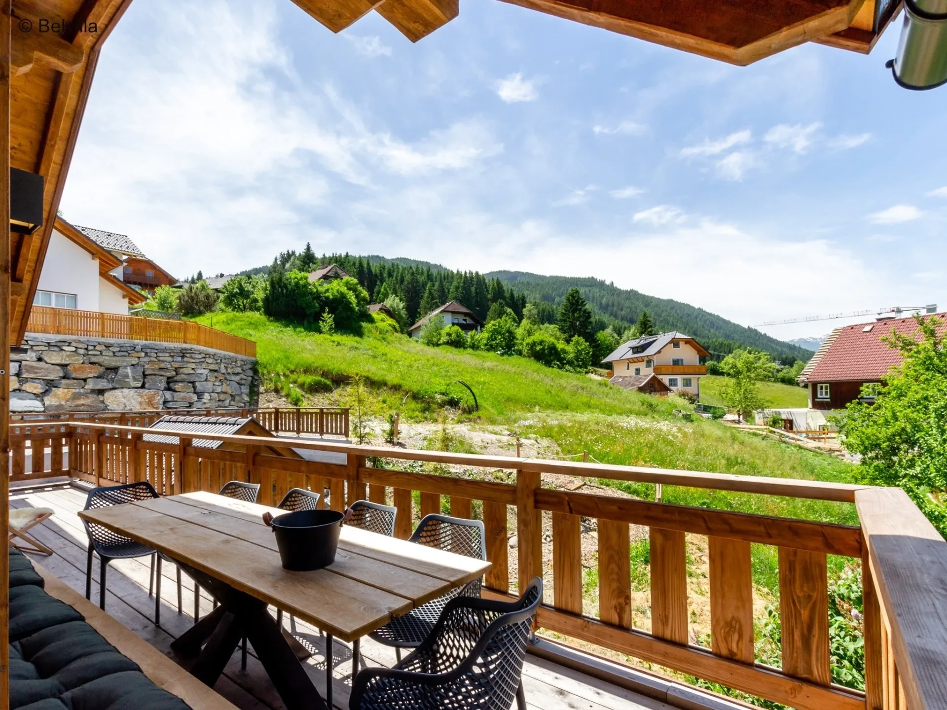 Terras met lange eettafel en uitzicht over de groene bergweides
