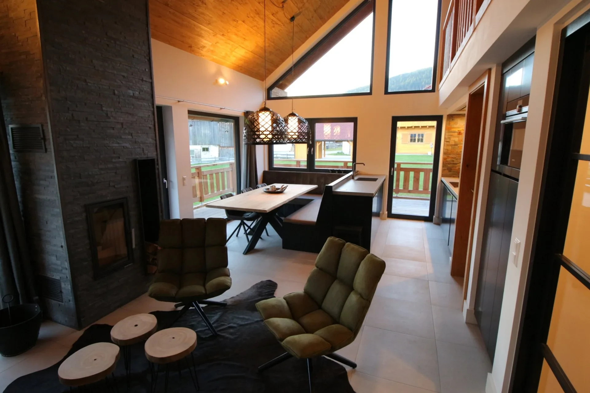 Woonkamer met eethoek, open haard en grote ramen