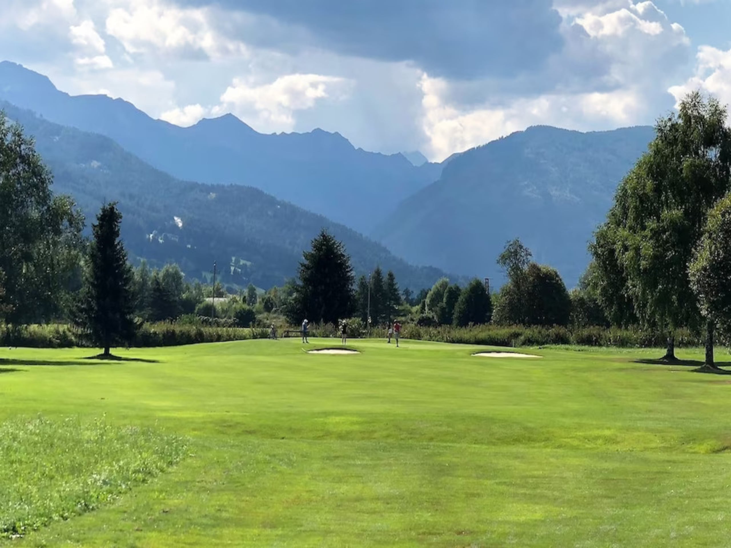 Golfbaan in een groen dal met bossen en bergen in de Salzburger Lungau